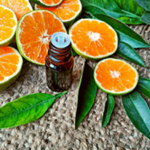 sliced oranges and an essential oil bottle on a jute rug