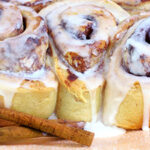 closeup of three frosted cinnamon rolls