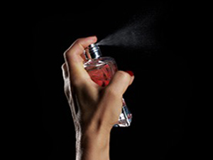 Person spraying perfume